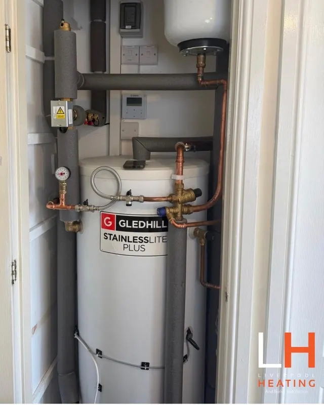 A heat pump hot water cylinder neatly fitted in a cupboard
